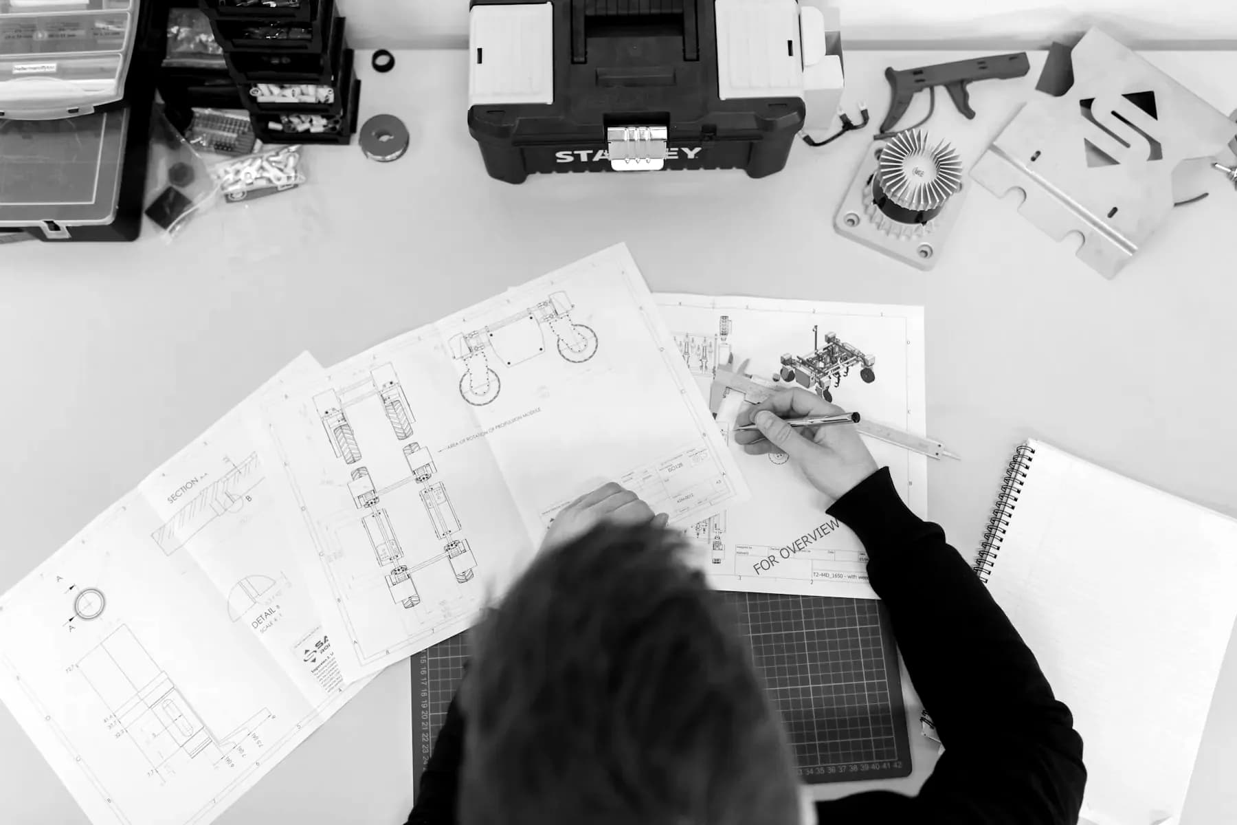 Engineer taking precision measurements over technical drawings