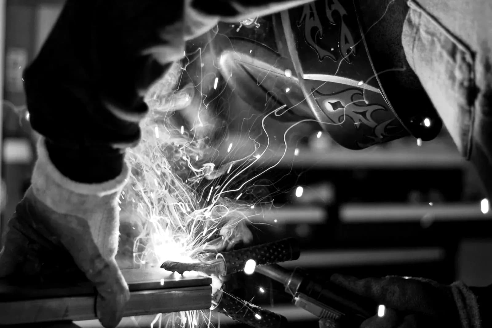 Certified welder at work behind a flame mask